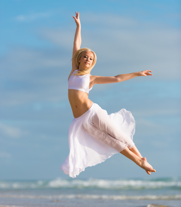 A woman dances near the sea