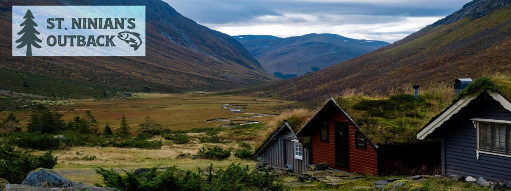 A mountain with cabins in front and the title St. Ninian's Outback
