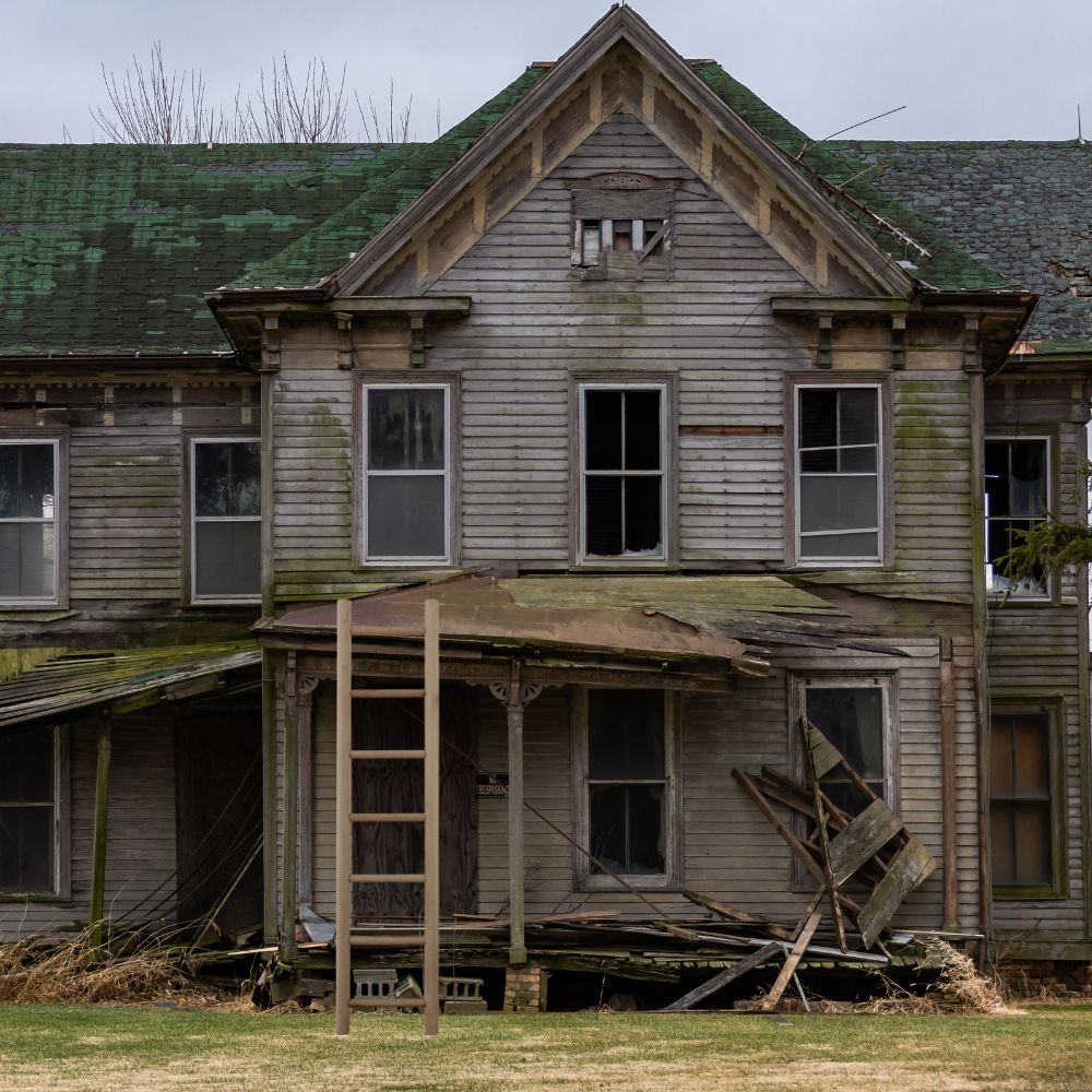 Old house with a ladder to the porch roof