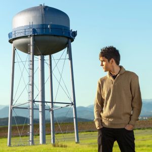 Teen male looking over his shoulder at a water tower