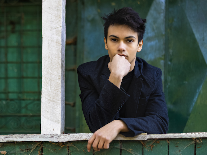 young man leaning on a porch rail